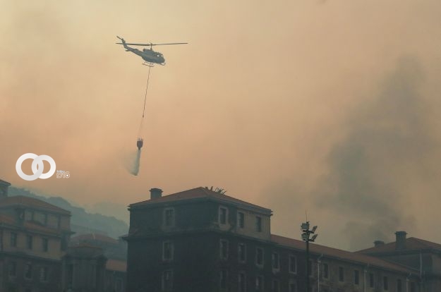 Un helicóptero lanza agua sobre la biblioteca. (PH: REUTERS/Mike Hutchings