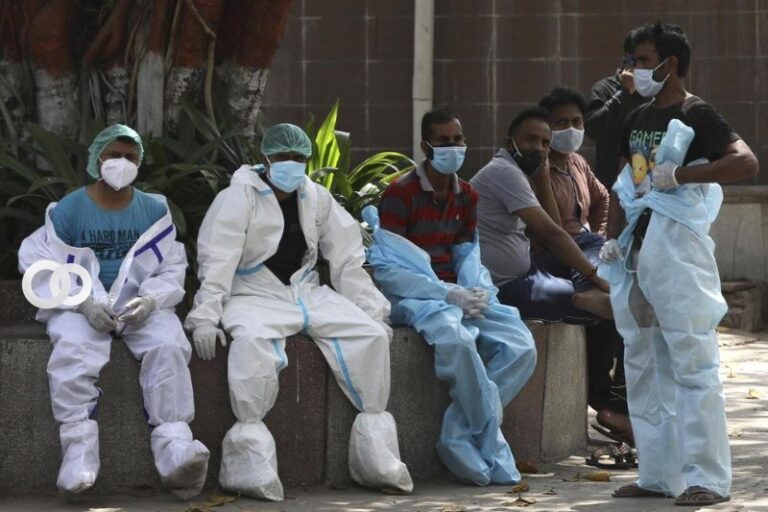 Los trabajadores de la salud descansan entre la cremación de las víctimas del COVID-19 en Nueva Delhi, India, el lunes 19 de abril de 2021 (AP Photo / Manish Swarup).
