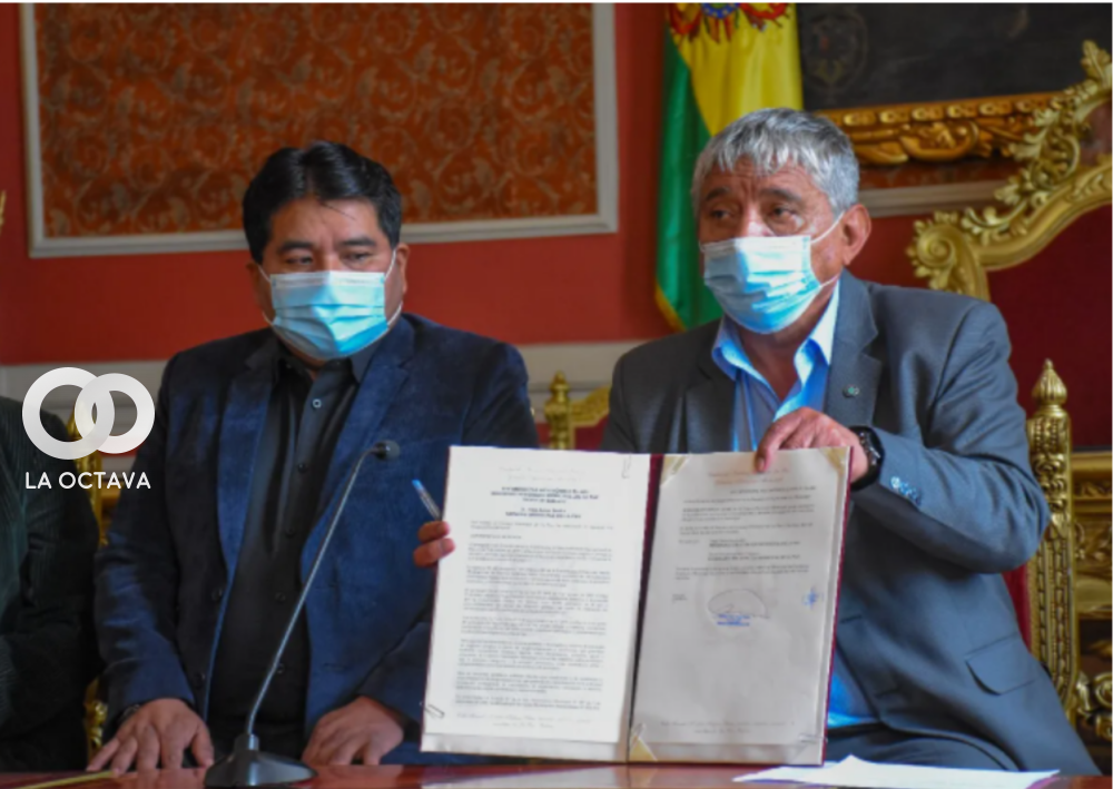 El alcalde Iván Arias muestra la ley promulgada este miércoles, a su lado mira el documento el concejal Lucio Quispe. Foto: AMUN.