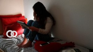 Una adolescente, en su habitación, consulta los mensajes en dispositivos móviles en Madrid