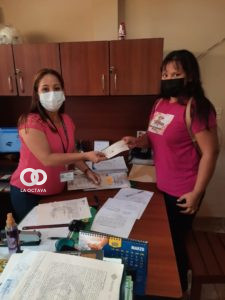 Trabajadora de supermecado recibiendo el cheque que gano