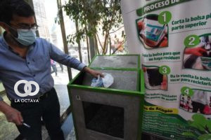 Persona del Edificio Municipal, reciclando bolsa plástica