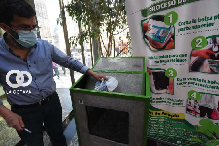 Persona del Edificio Municipal, reciclando bolsa plástica