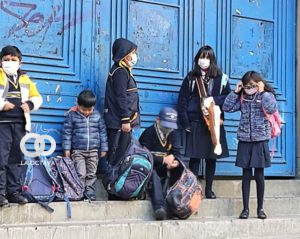 Niños de Primaria, esperando en la calle que los dejen ingresar