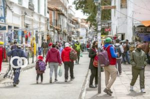 Personas caminan por una céntrica calle de la ciudad de Sucre
