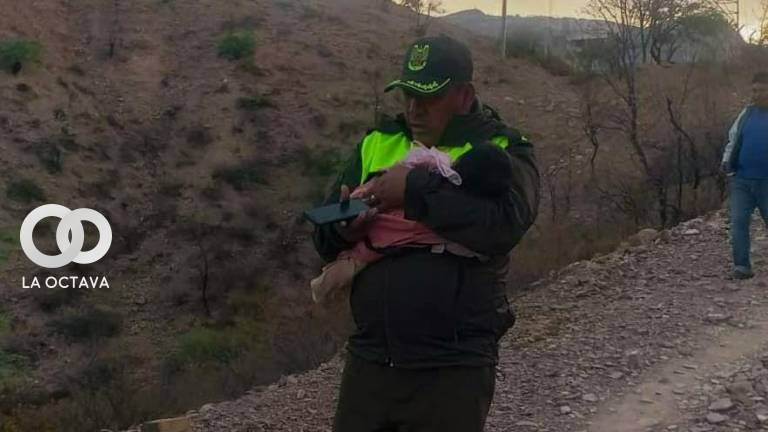 Policía carga en brazos a la bebé encontrada en el tanque de agua. Foto: Policía Boliviana.