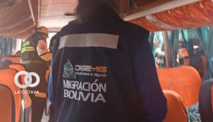 De espaldas, una funcionaria de Migración realiza controles a pasajeros de un bus. Foto. Migración Bolivia