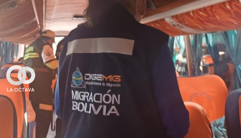 De espaldas, una funcionaria de Migración realiza controles a pasajeros de un bus. Foto. Migración Bolivia