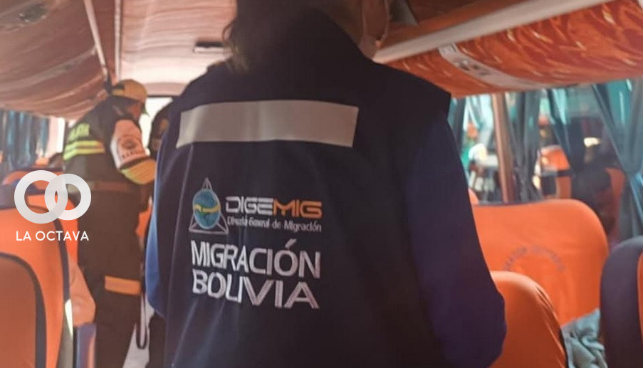 De espaldas, una funcionaria de Migración realiza controles a pasajeros de un bus. Foto. Migración Bolivia